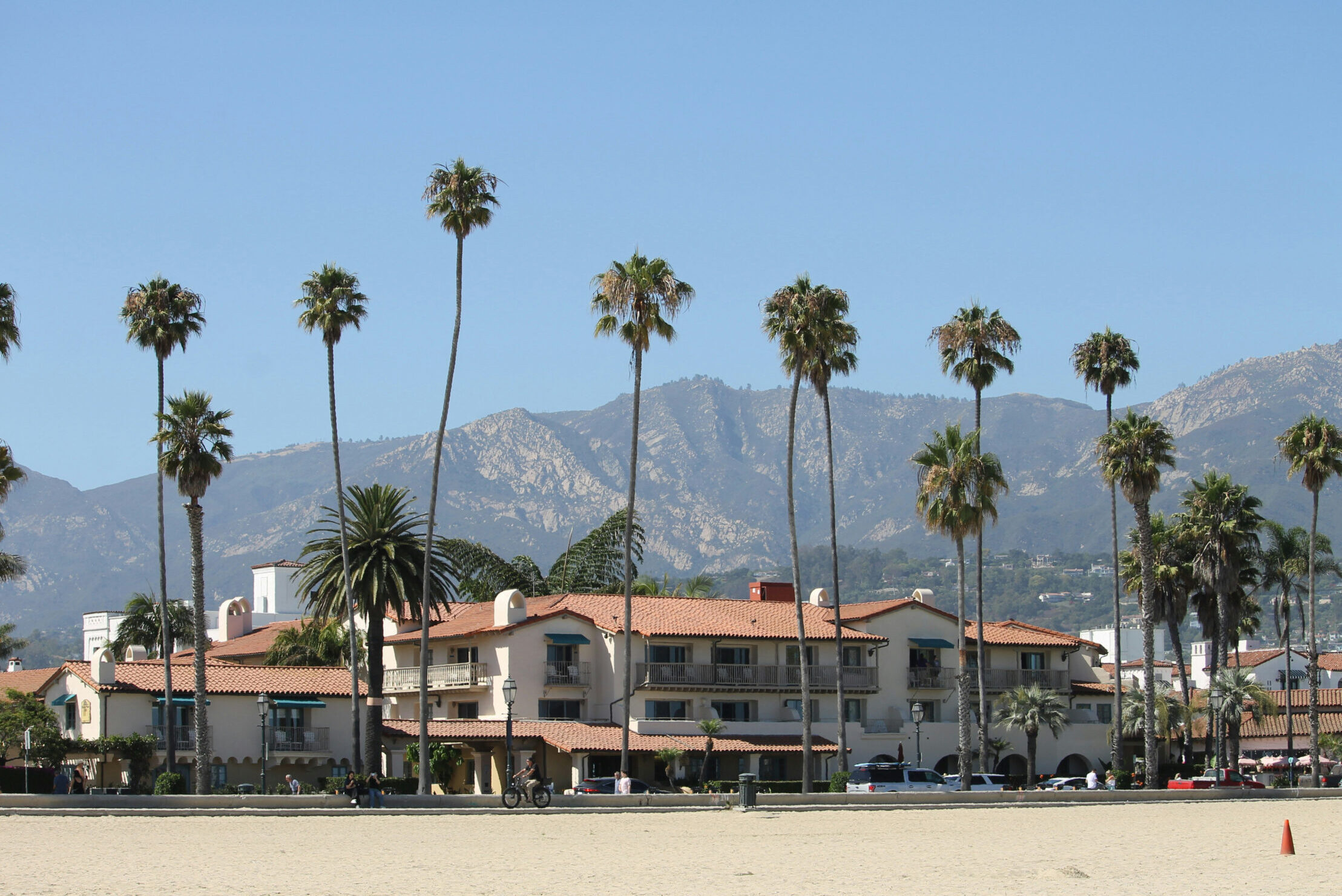 Playa de California con palmeras, casas y montañas de fondo